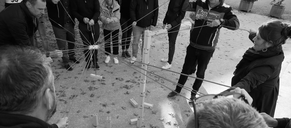 Un groupe relié par des cordes pendant un jeu coopératif